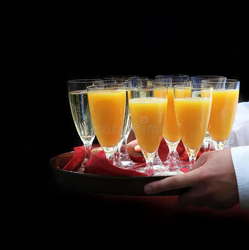 A Waiter Served Orange Juice And Champagne Stock Photo