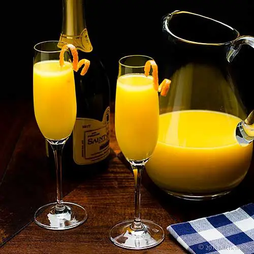 Mimosa Cocktails with orange twist garnish, champagne bottle and ...